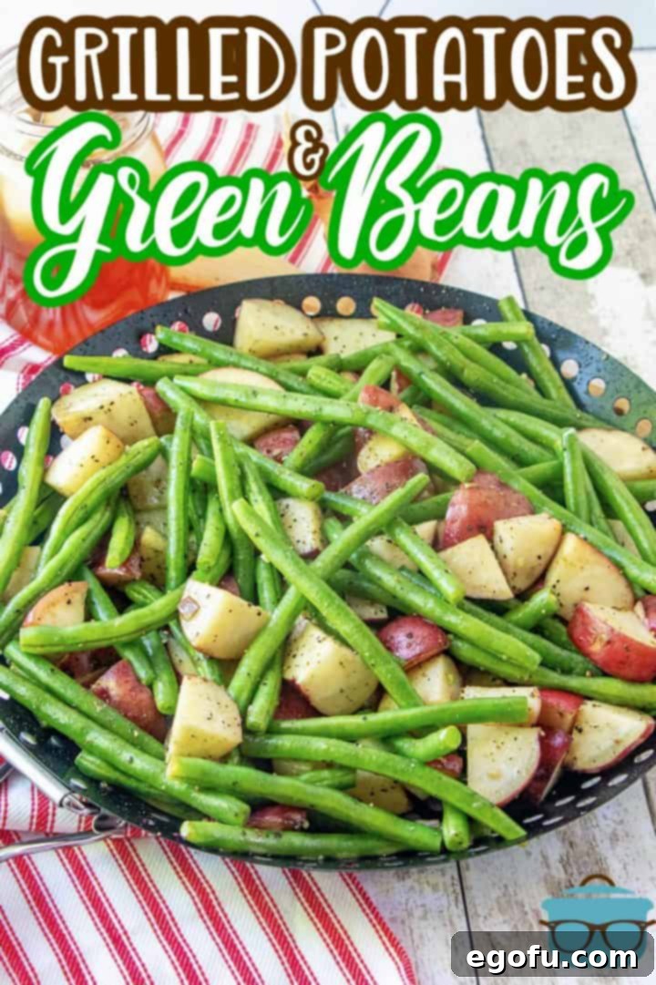 Close-up of perfectly grilled red potatoes and green beans in a black grill pan, showing tender texture and a slight char.