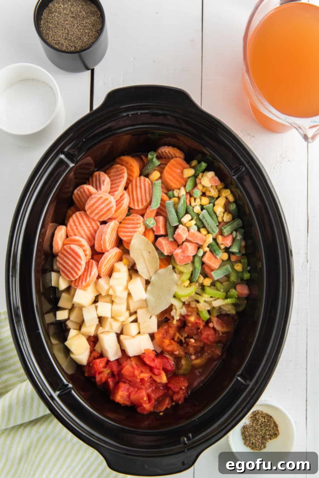 One Pot Comfort Vegetable Soup 6 All prepared vegetables including frozen mixed vegetables, carrots, peas, corn, diced tomatoes, tomatoes and okra, and diced potato added to a large Crock Pot.