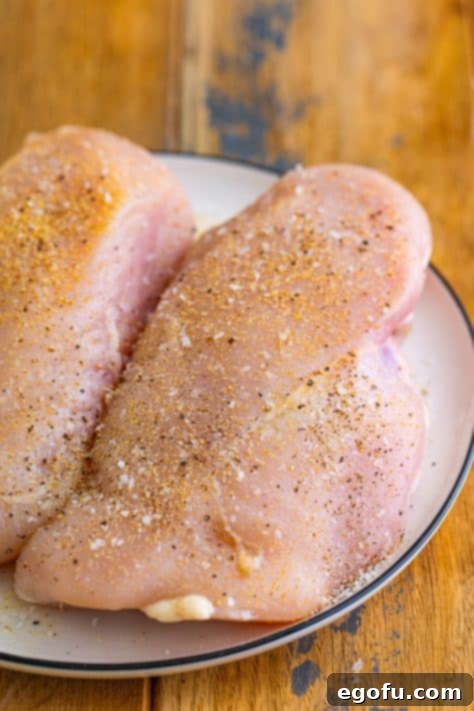 Seasoned chicken breasts on a plate.