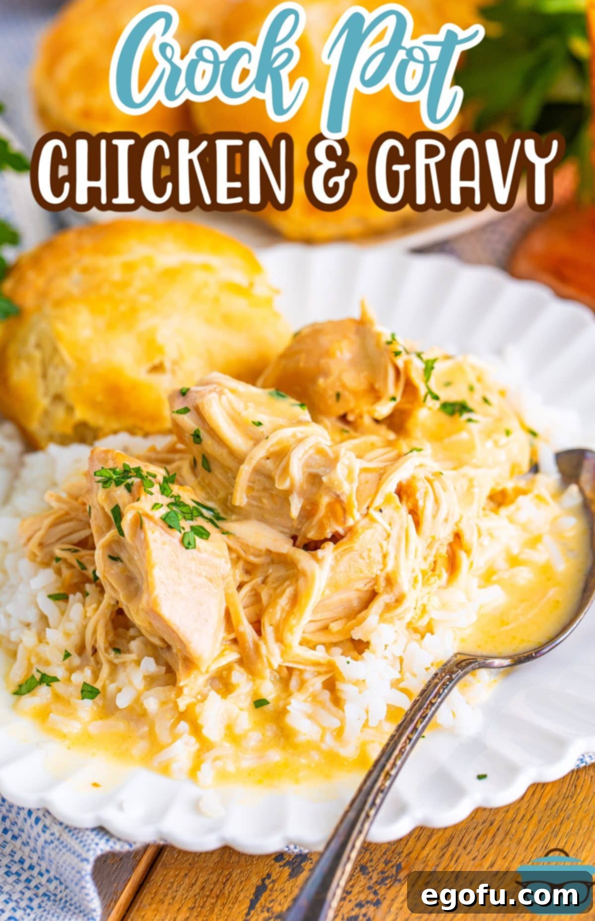 A plate with Crock Pot chicken and Gravy and a spoon holding a bite, highlighting the rich texture.