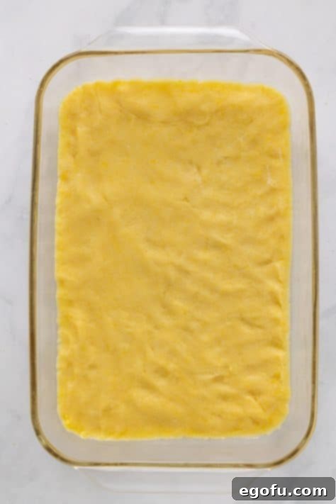 Cookie dough pressed into a baking dish.