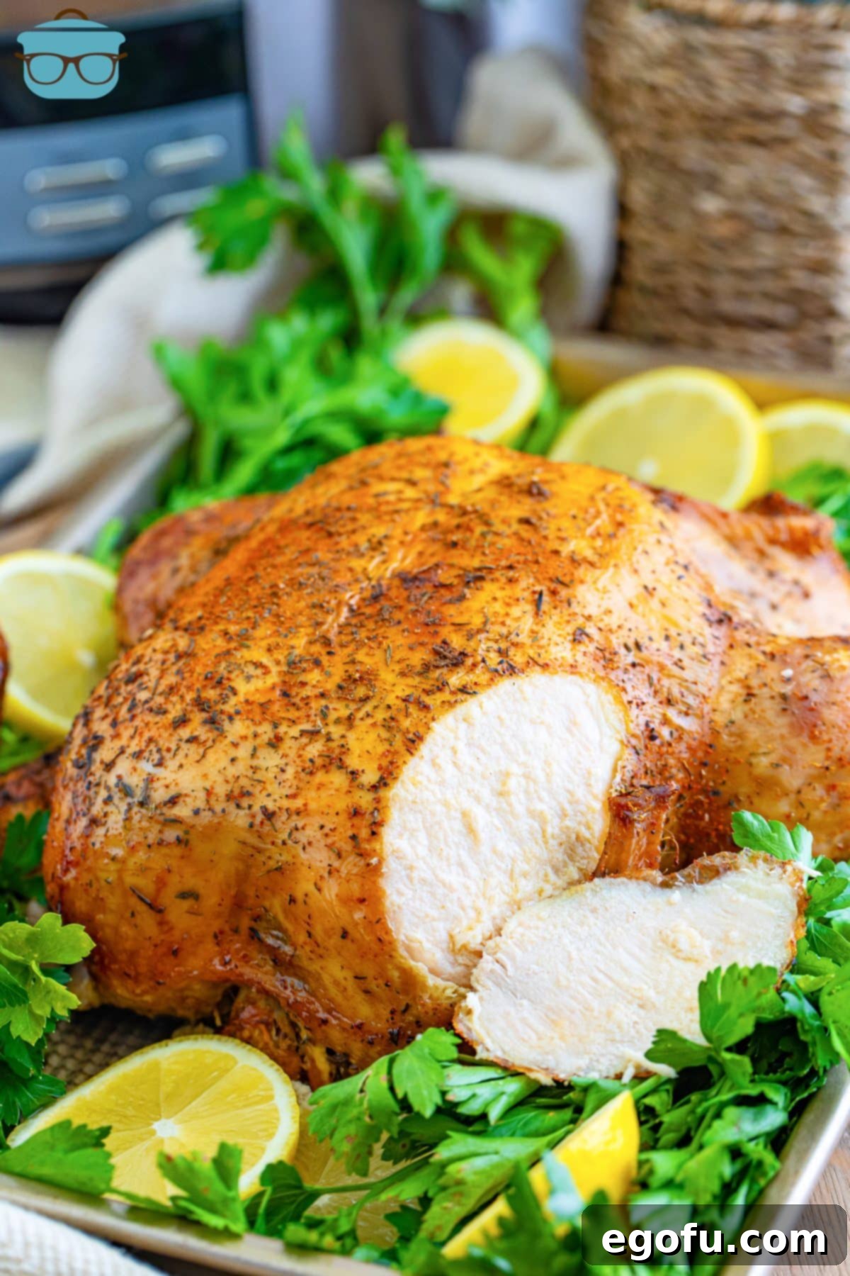 A whole Crock Pot Rotisserie Chicken with some slices.