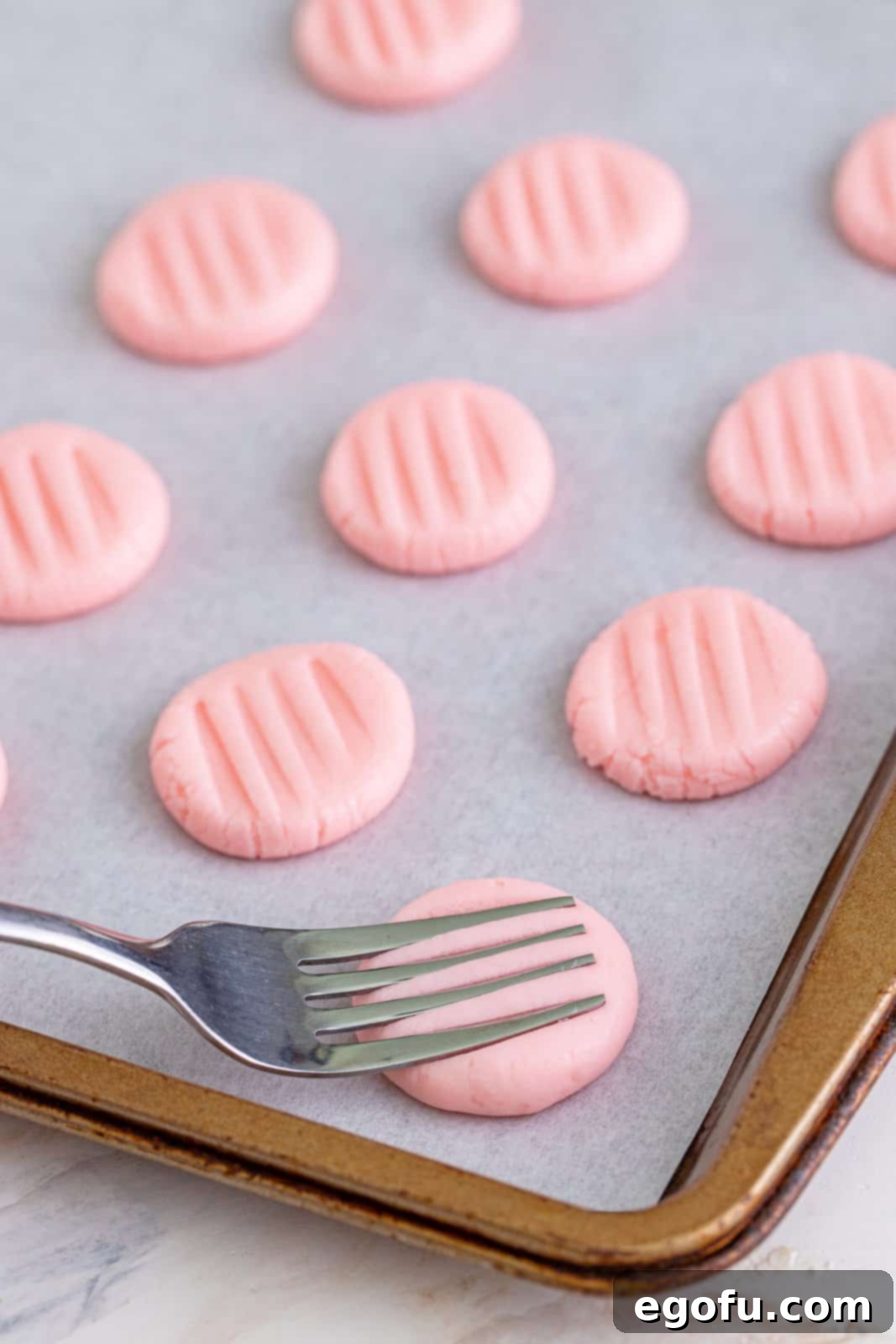 Refreshing Finales 9 A fork gently pressing down on a flattened cream cheese mint to create decorative ridges, demonstrating the shaping technique.