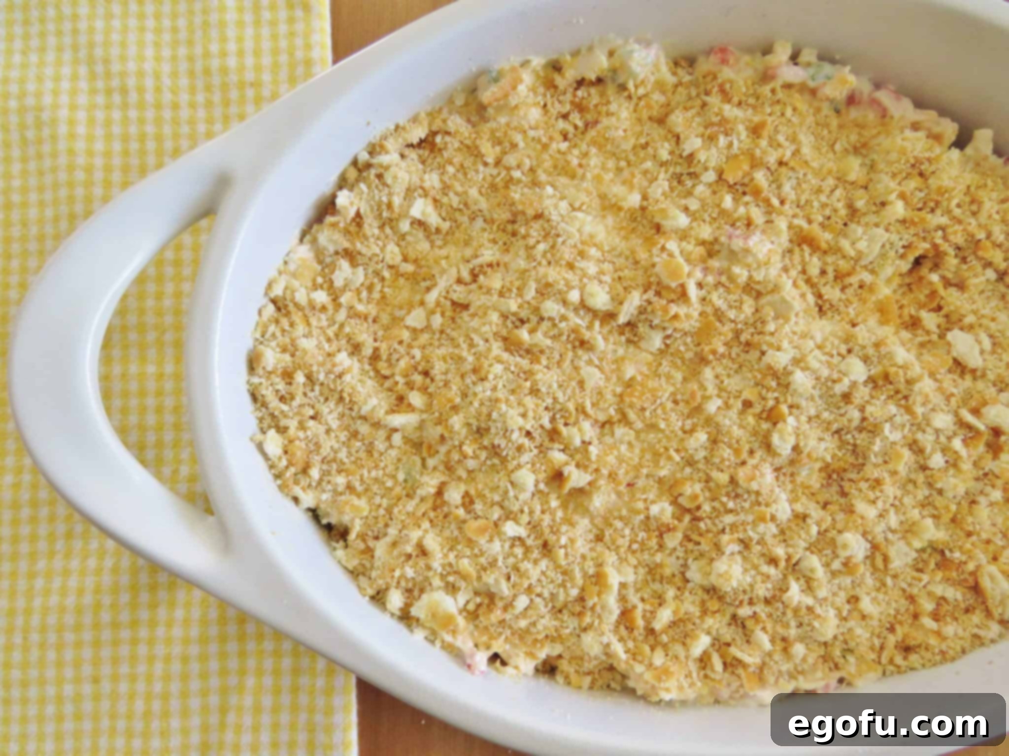 Crushed Ritz crackers spread evenly over the top of the pimiento cheese dip mixture, creating a delicious crust.