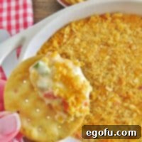 Warm Pimiento Cheese Dip in a white dish with a scoop missing.