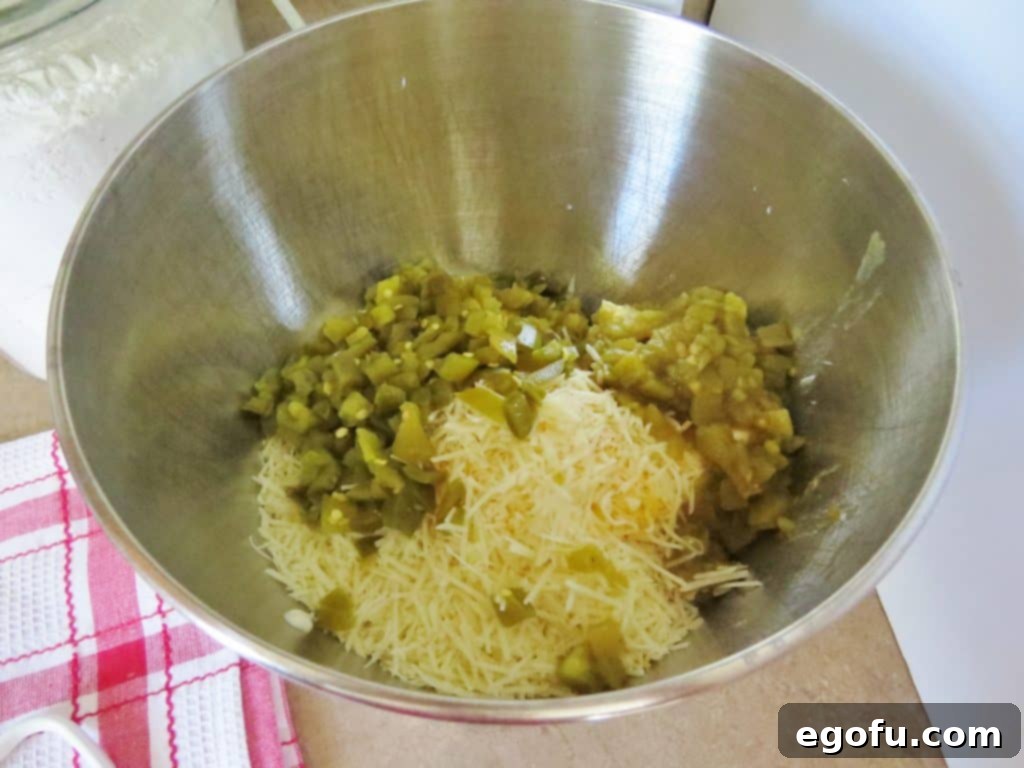 Baked Jalapeño Cheese Dip 6 Cream cheese, mayonnaise, mozzarella, Parmesan Cheese, chopped green chilies and jalapeños in a large mixing bowl, ready to be mixed.