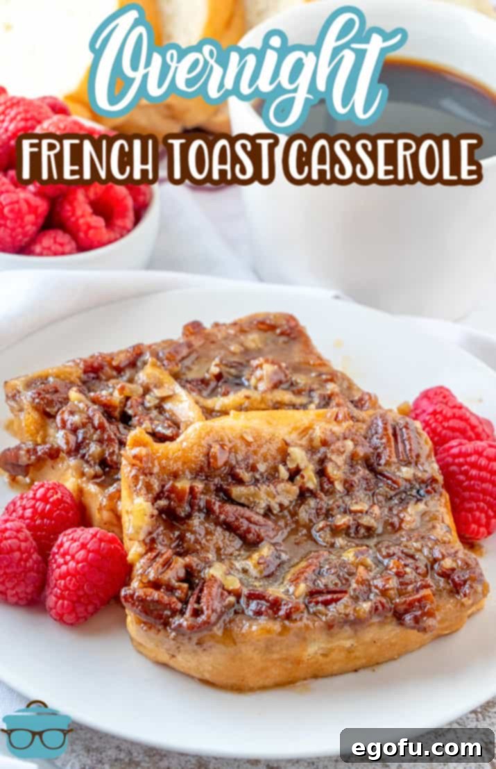 Two slices of golden-brown Pecan Praline French Toast on a white plate, garnished with fresh red raspberries.