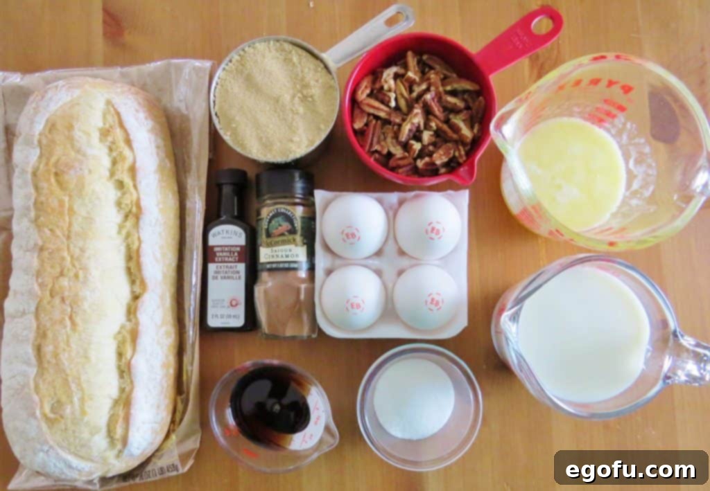Collection of fresh ingredients for Pecan Praline French Toast: sliced French bread, eggs, brown sugar, pecans, butter, vanilla, and cinnamon.
