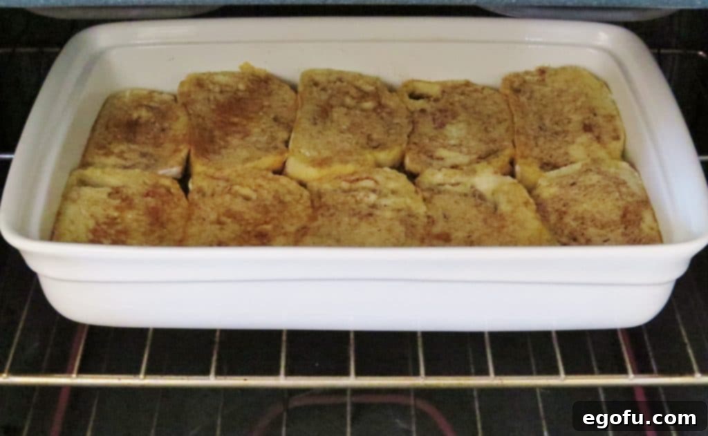 The Overnight French Toast Casserole baking in the oven, turning golden brown and bubbling.