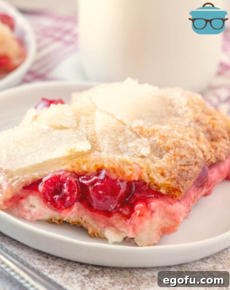 slice of crescent roll cheesecake cobbler on a white plate served with milk.