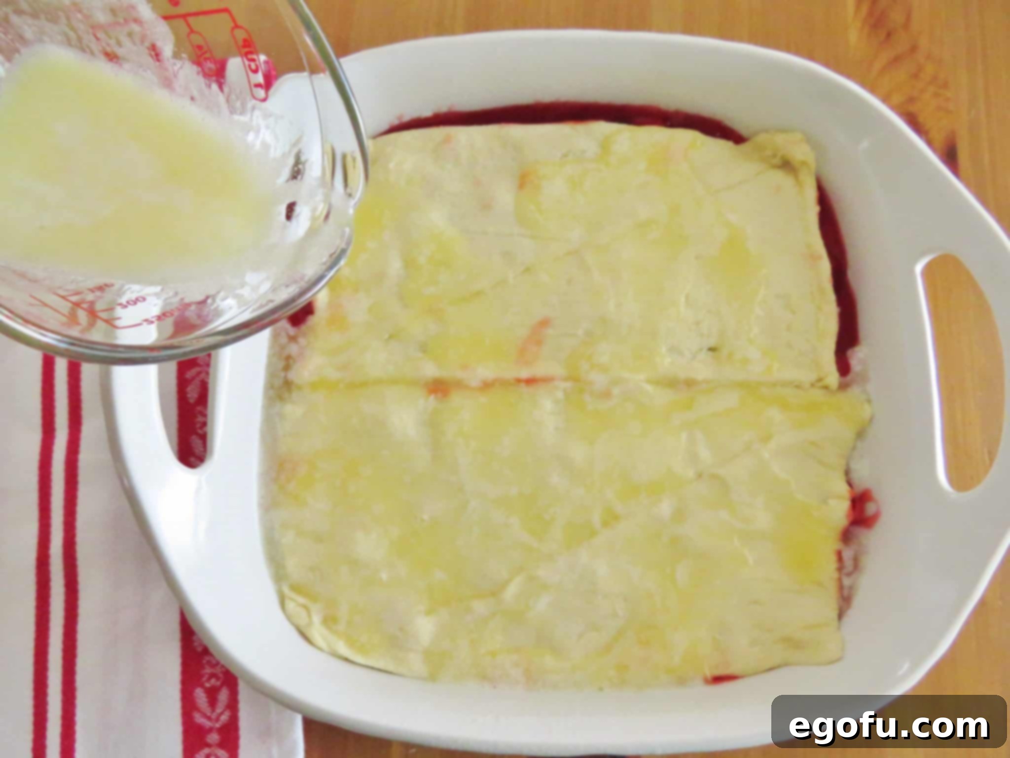 pouring melted butter on top of crescent roll dough.