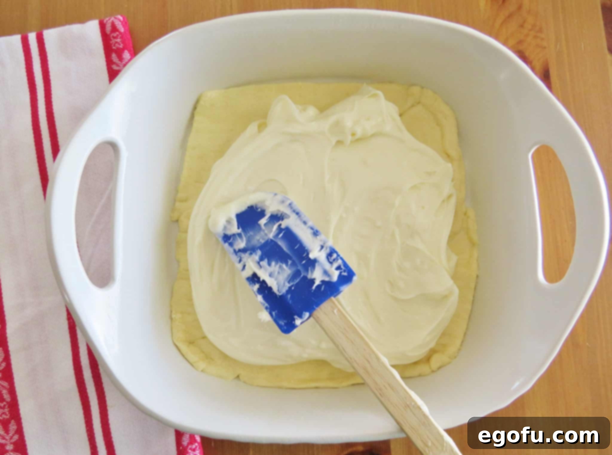 spreading cream cheese mixture on top of crescent roll dough.