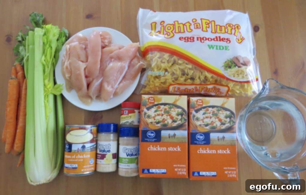 Chicken Noodle Soup ingredients laid out: chicken stock, poultry seasoning, garlic powder, onion powder, boneless chicken, diced carrots, diced celery, cream of chicken soup, water, egg noodles, salt & pepper.