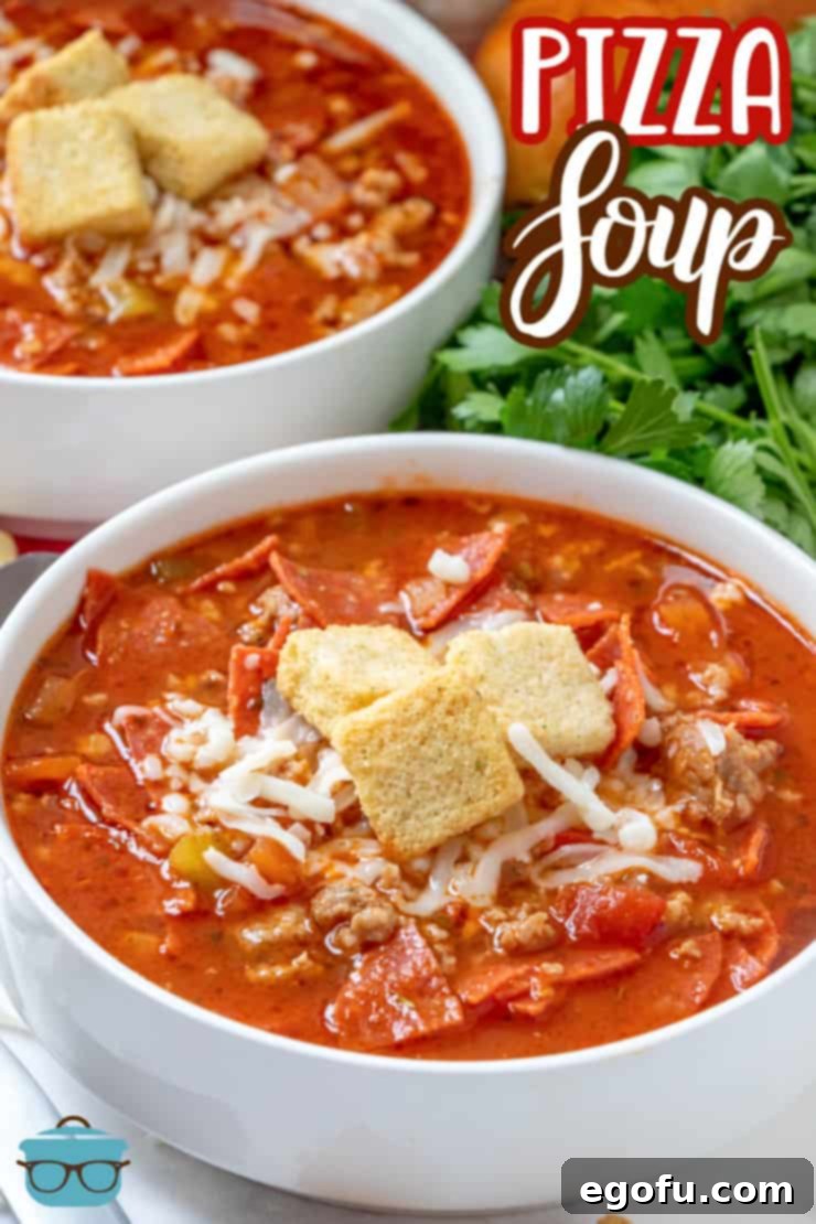 Two white bowls holding a serving each of pizza soup with a fresh bunch of parsley on the side.