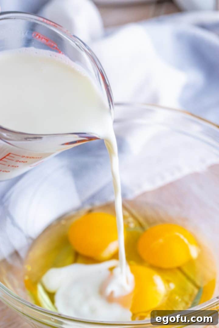 Milk, eggs, melted butter, and vanilla extract are shown being poured into a small glass mixing bowl, forming the rich base for the French toast batter.