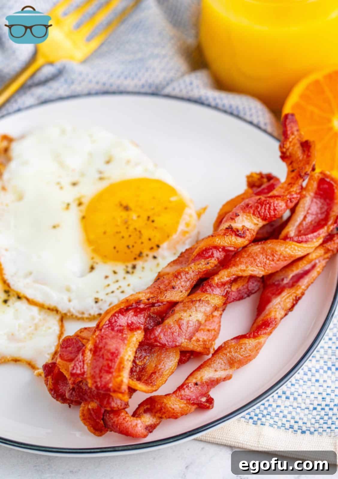 Crispy Air Fryer Bacon Spirals 2 Crispy Air Fryer Twisted Bacon on a plate, served with fluffy scrambled eggs, ready for a delicious breakfast.