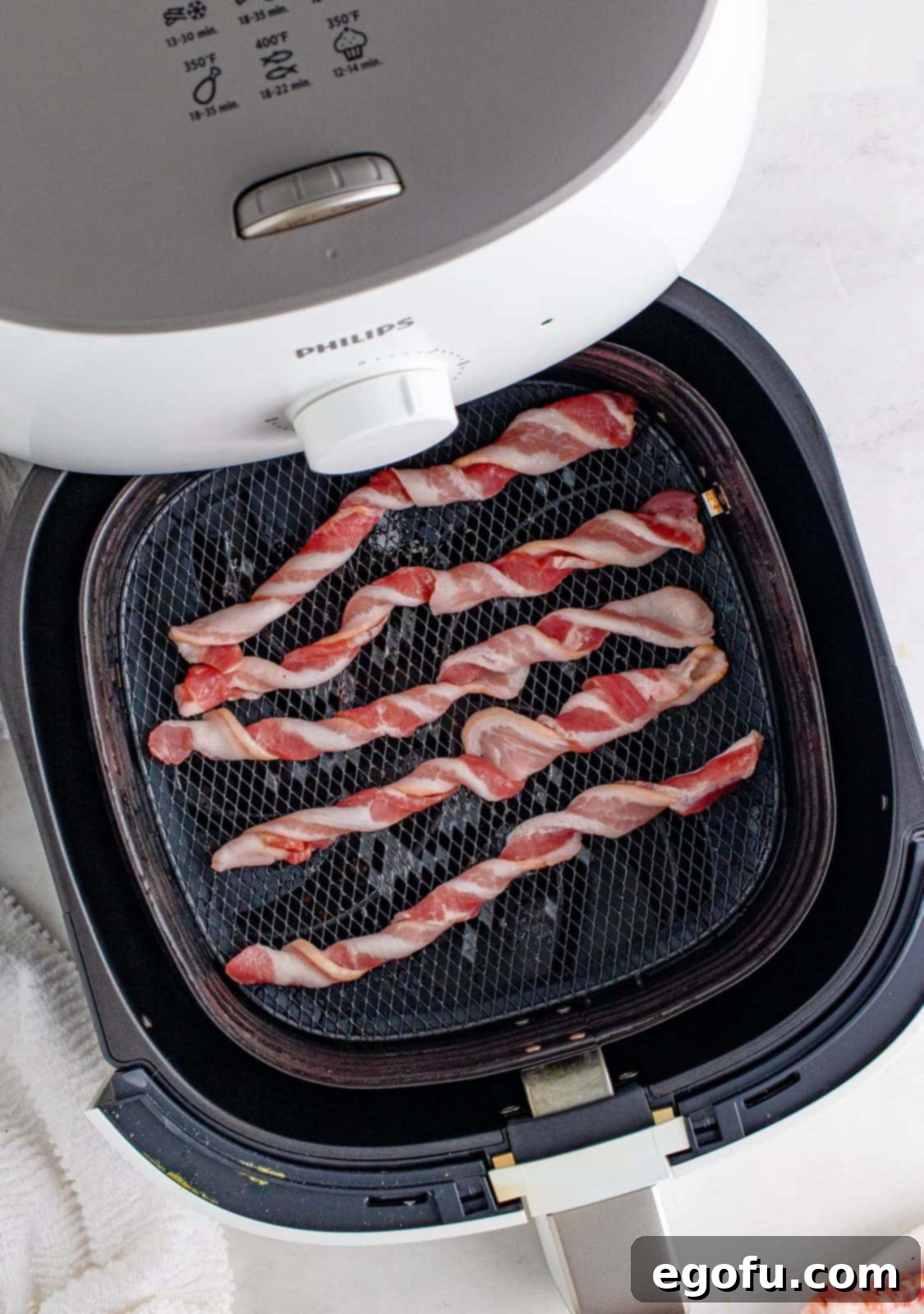 Crispy Air Fryer Bacon Spirals 5 Twisted bacon strips neatly arranged in a single layer within the air fryer basket, ready for cooking.