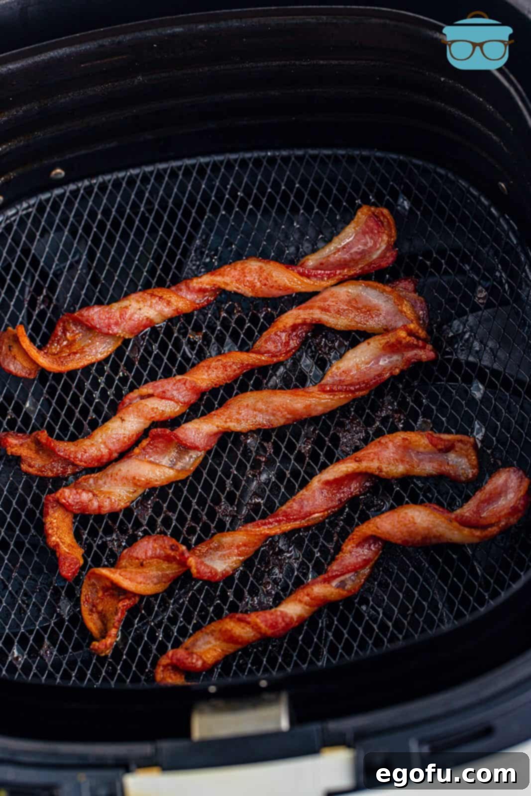 Crispy Air Fryer Bacon Spirals 6 Golden-brown and perfectly crispy Air Fryer Twisted Bacon strips inside the air fryer basket after cooking.