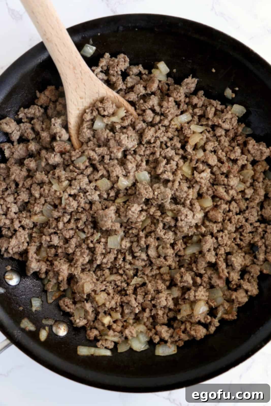 Ground beef and onion cooked in saute pan.