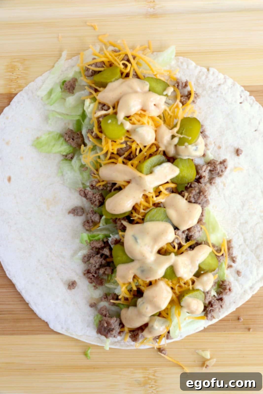 Ingredients for wraps layered on top of tortilla.