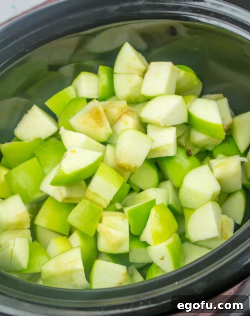 chopped Granny Smith apples in a 6-quart oval slow cooker, before cooking.