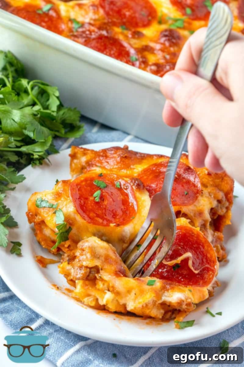 Puffy Pizza Bake 9 single serving of Bubble Up Pizza on a small white plate and fork.