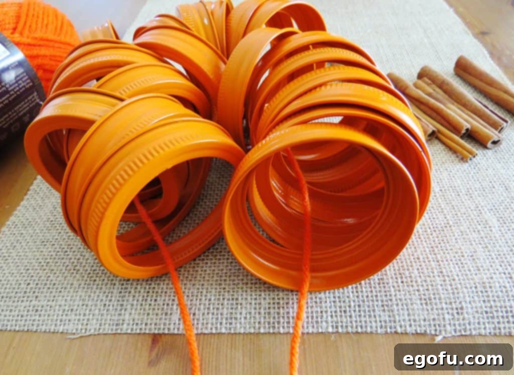 Autumn Jar Lid Pumpkins 6 mason jar lids threaded with orange yarn for pumpkin assembly