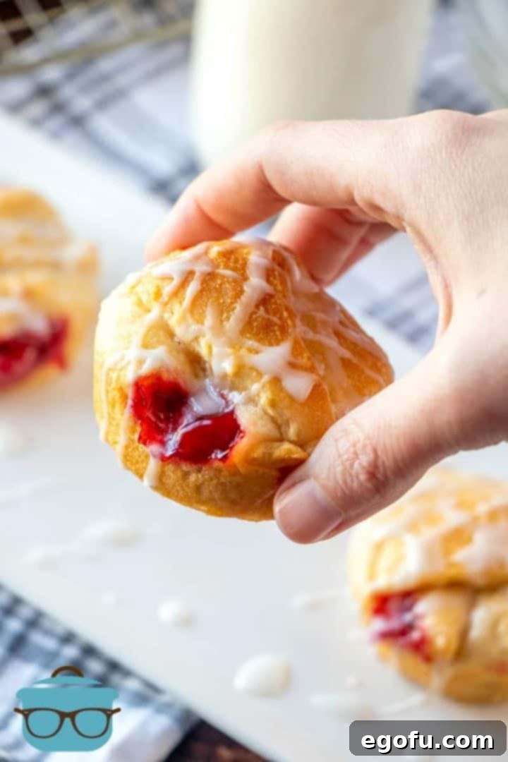 a cherry pie bite being held up by a hand.