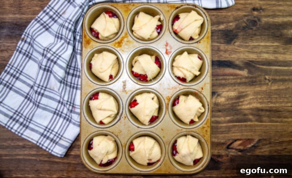 folding crescent roll dough around cherry pie filling.