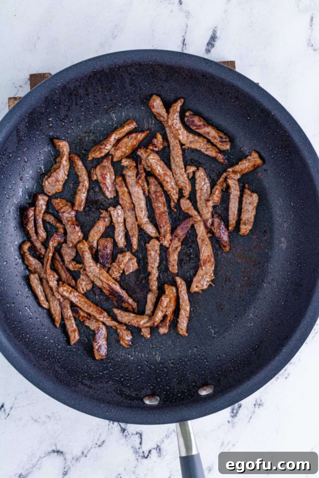 Sizzling Beef Fried Rice 5 Beef strips being cooked in pan.