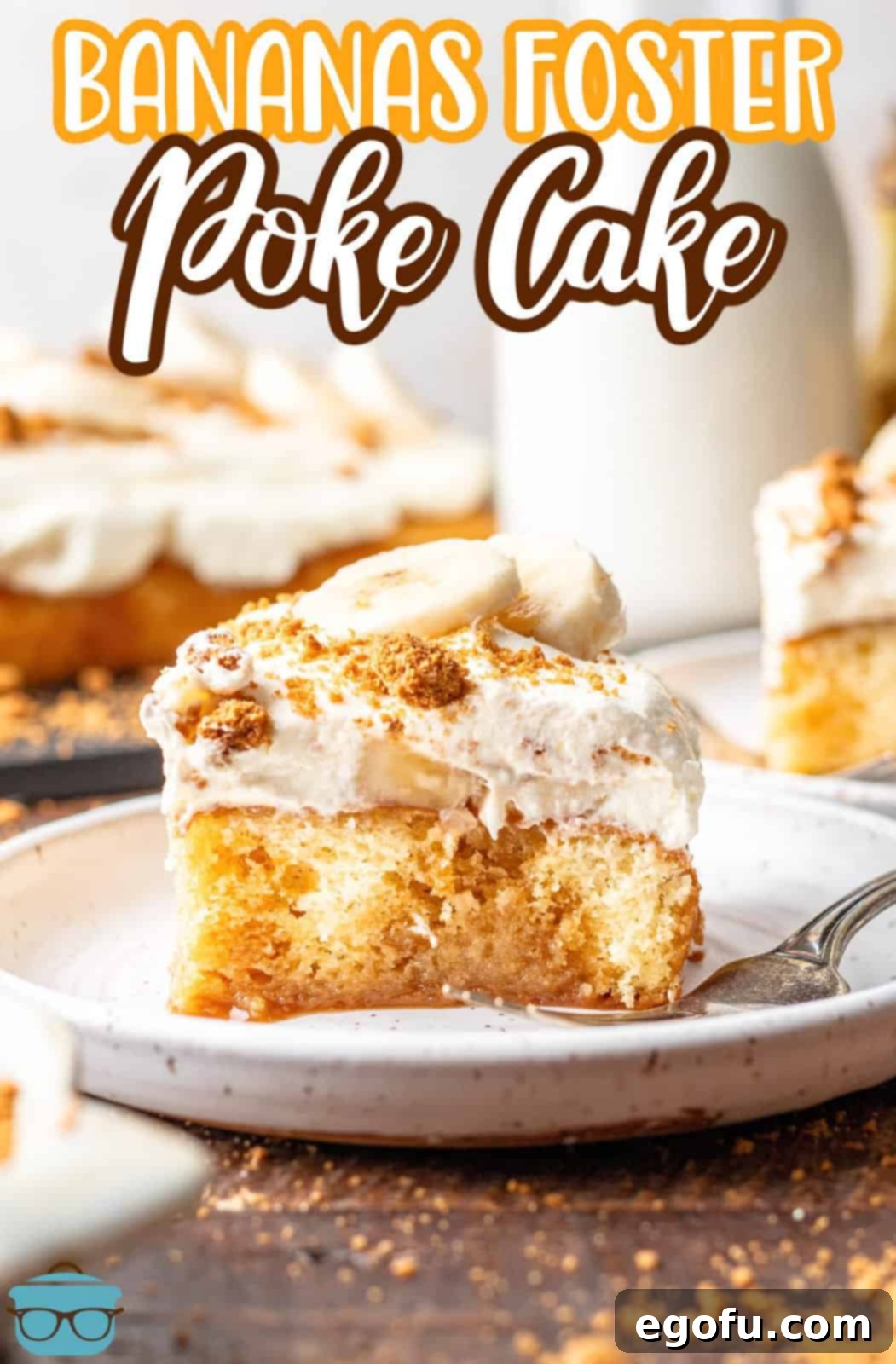 New Orleans Bananas Foster Poke Cake 12 slice of Bananas Foster Poke Cake on a small round white plate with a clear glass of milk in the background.