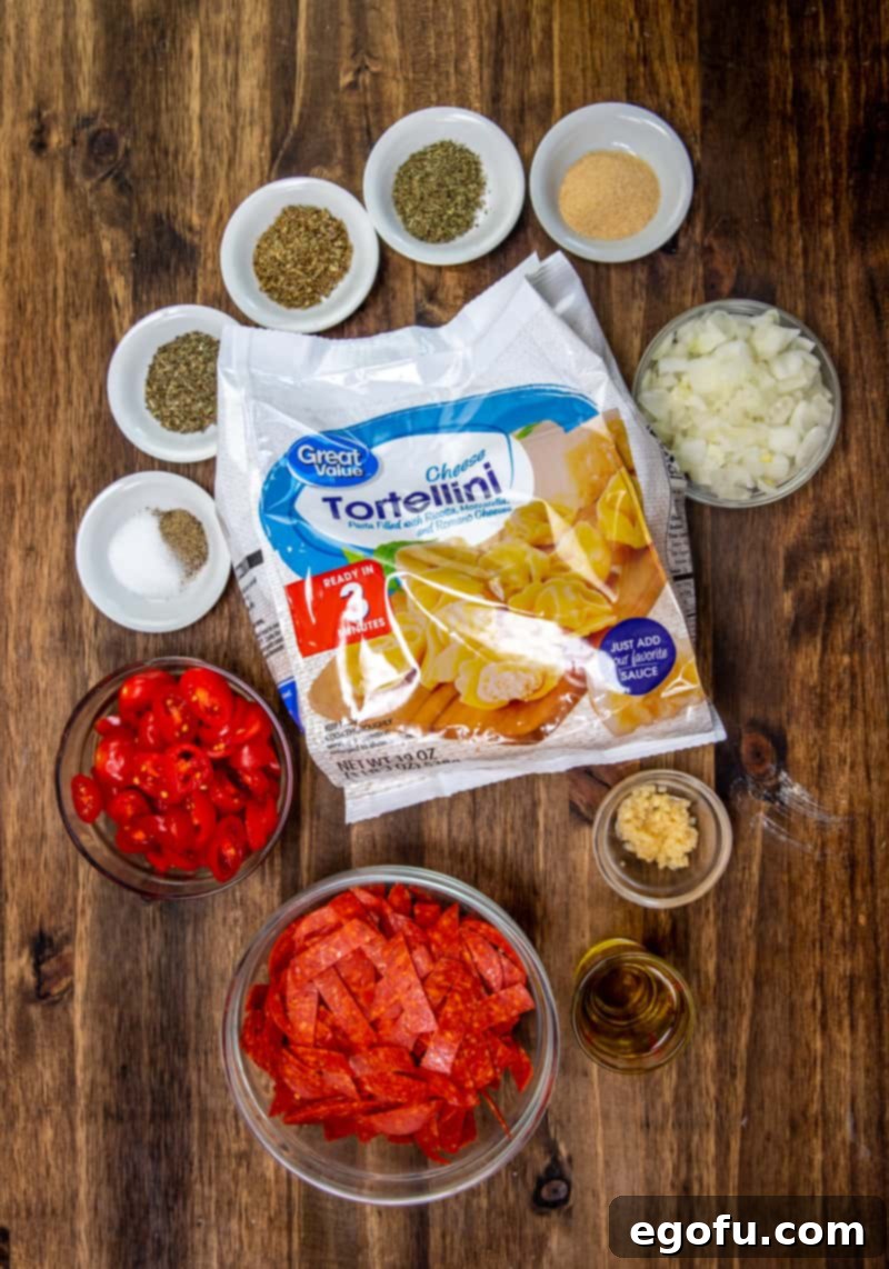 Creamy One Skillet Tortellini 4 olive oil, onion, garlic cloves, grape tomatoes, pepperoni, dried basil, dried oregano, Italian seasoning, garlic powder, salt, pepper, cheese tortellini pasta, Parmesan cheese.