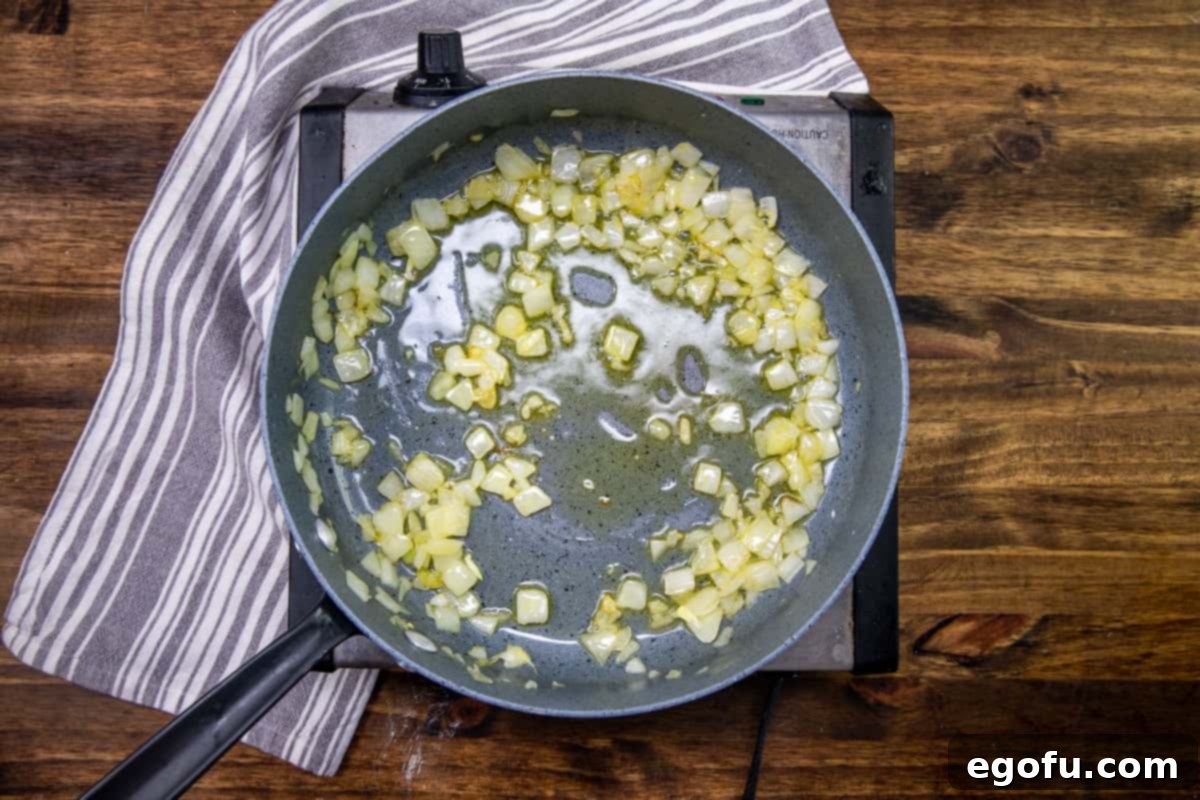 Creamy One Skillet Tortellini 5 diced onions cooking in a hot skillet with olive oil.
