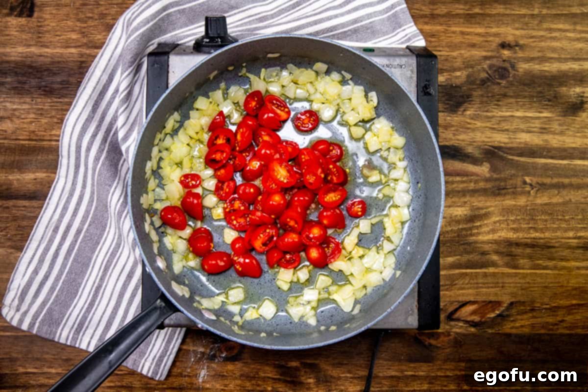 Creamy One Skillet Tortellini 6 minced garlic and slice grape tomatoes added to skillet with cooked onions and olive oil.