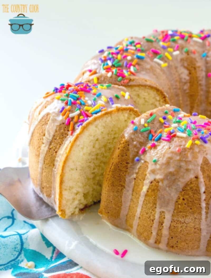 Melted Ice Cream Cake with icing and sprinkles on a white cake plate.