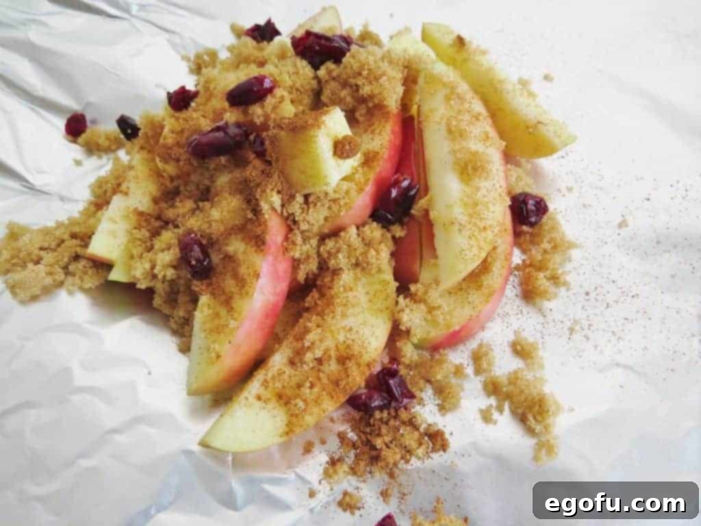 sliced fuji apples, brown sugar, raisins and chopped pecans layered on a sheet of aluminum foil.