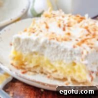 A delicious homemade Coconut Cream Pie Bars recipe, showcasing its creamy layers and toasted coconut garnish.