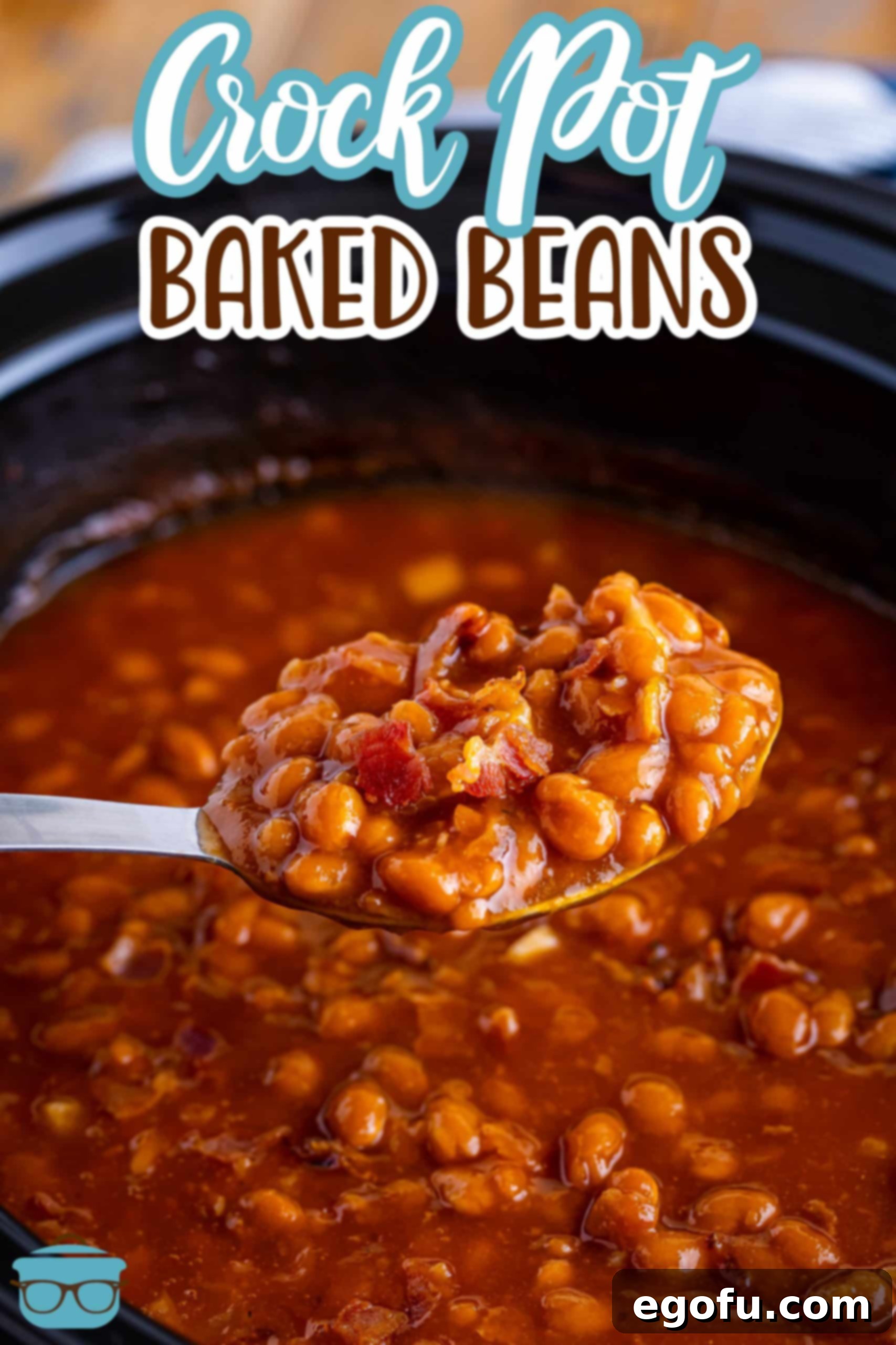 A serving spoon lifting a generous scoop of rich, saucy Crock Pot Baked Beans from a full bowl, showcasing the tender beans and delicious sauce.