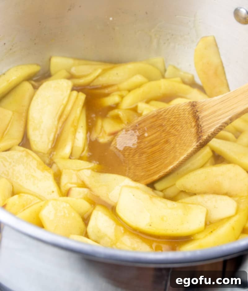 Softened, cooked apples in a thick, syrupy mixture, showcasing the rich texture of the no-bake apple pie filling before it's spooned into the crust.