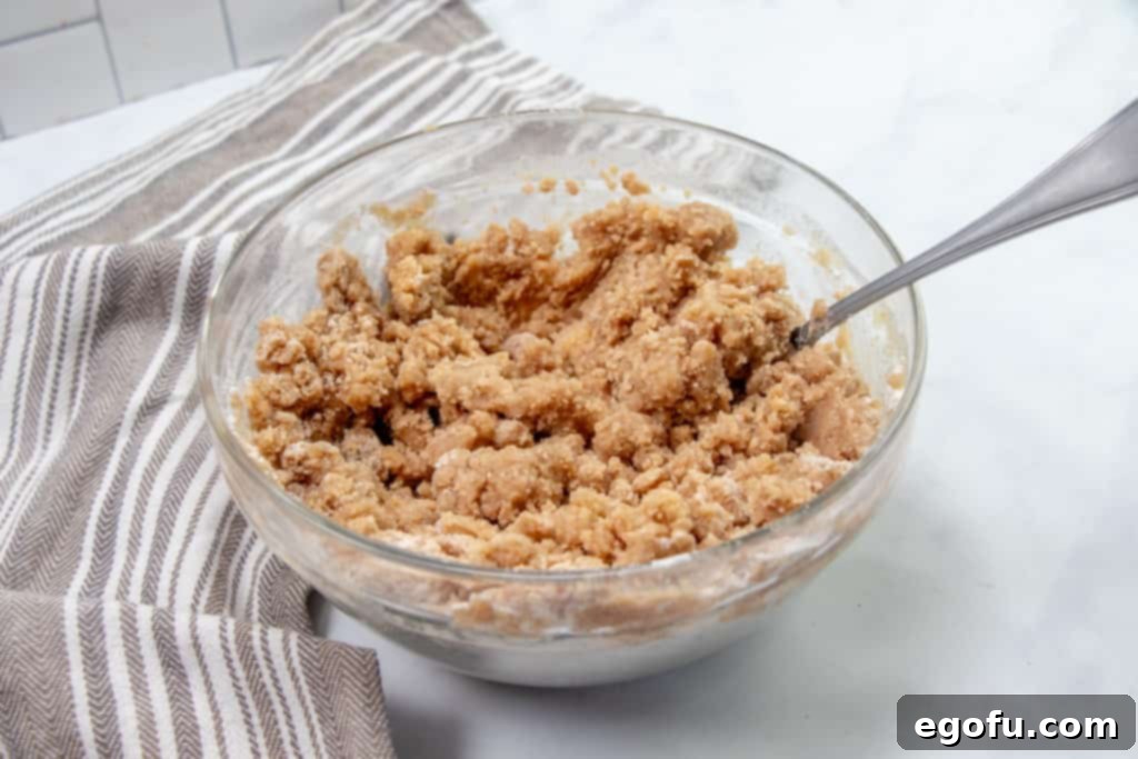melted butter combined with flour, cinnamon and brown sugar mixed with a fork in a bowl.