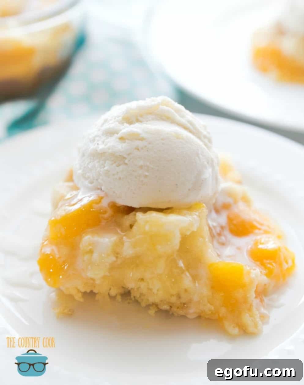 A perfectly plated slice of Easy Peach Cobbler Cake with a scoop of melting vanilla ice cream and a drizzle of icing.