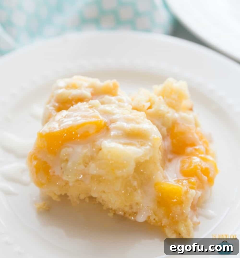 A freshly baked slice of Peach Cobbler Cake without ice cream, showing the distinct layers and golden crumble.