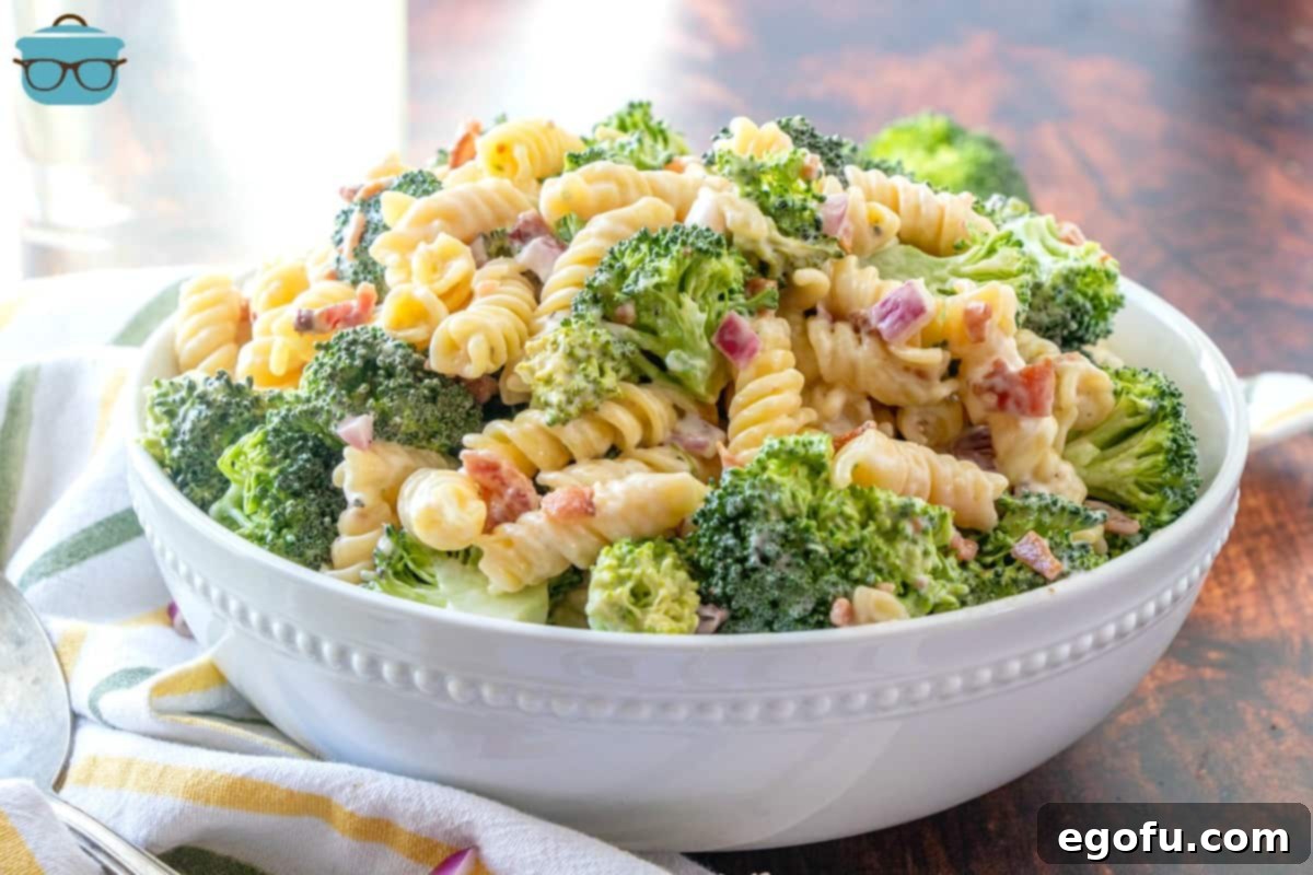 Creamy Bacon Broccoli Pasta Salad in a beautiful white serving bowl, garnished with fresh parsley.