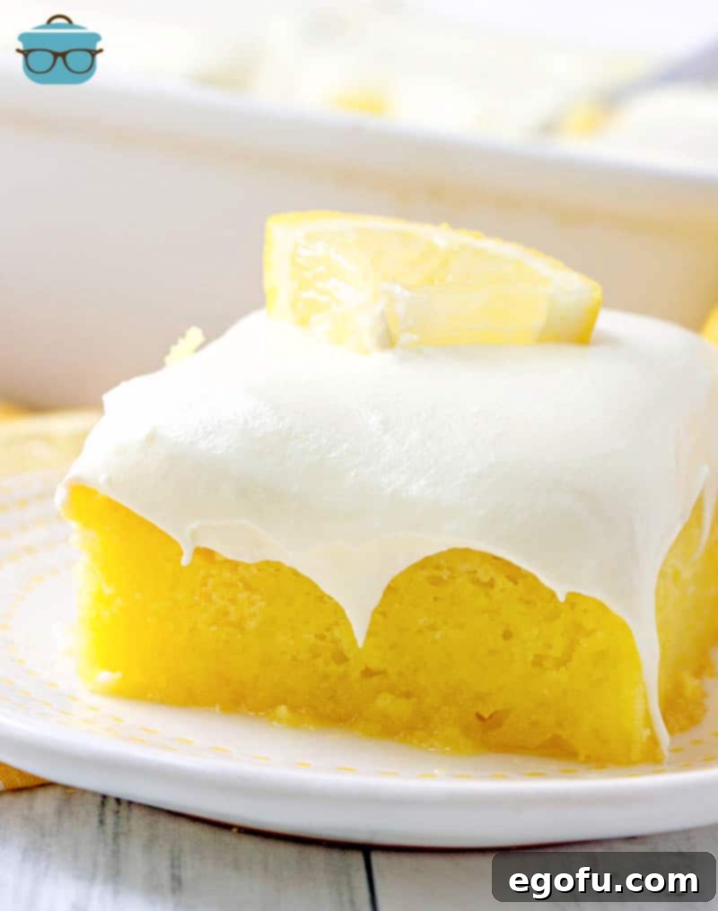 Zesty Lemon Drop Bliss 12 A close-up of a beautifully cut slice of Lemon Drop Cake, showing the moist cake, vibrant glaze, and airy whipped frosting layers.