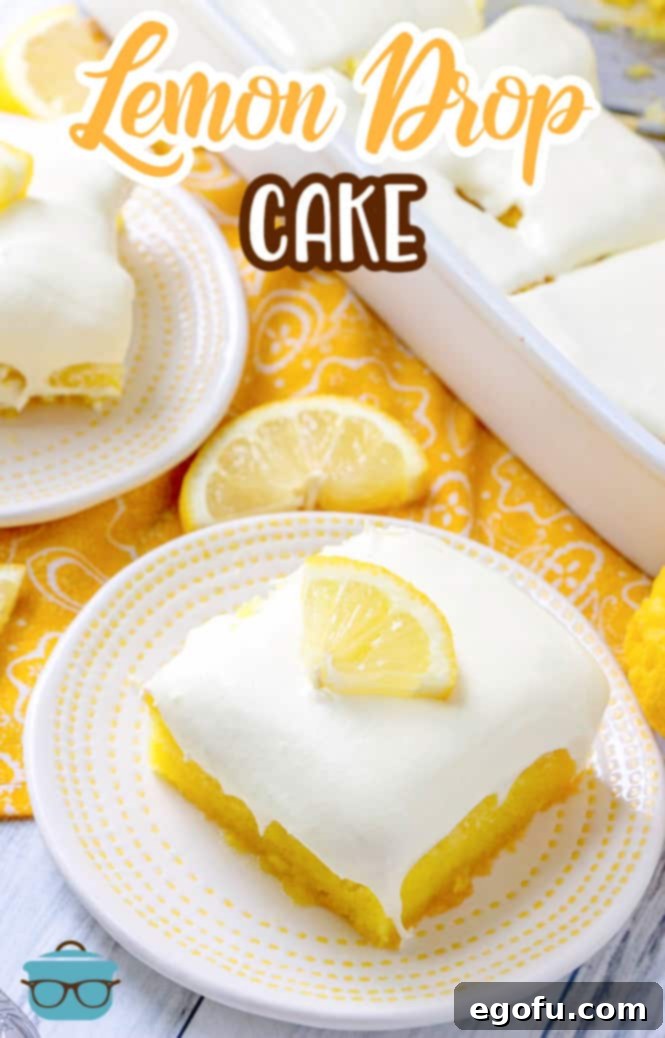 Zesty Lemon Drop Bliss 3 A beautifully frosted Lemon Drop Cake, showcasing its light and fluffy whipped lemon frosting, ready for slicing.