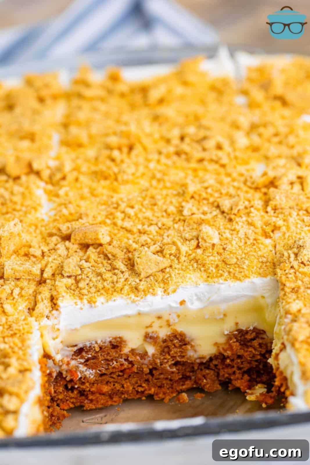 Super Moist Carrot Poke Cake 2 A Carrot Poke Cake in a baking dish with a large piece missing.