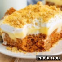 Super Moist Carrot Poke Cake 10 A large slice of Carrot Poke Cake with a bite missing.