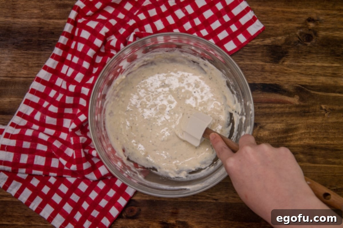 Cheesy Pepperoni Poppers 6 milk added to flour batter in a bowl.
