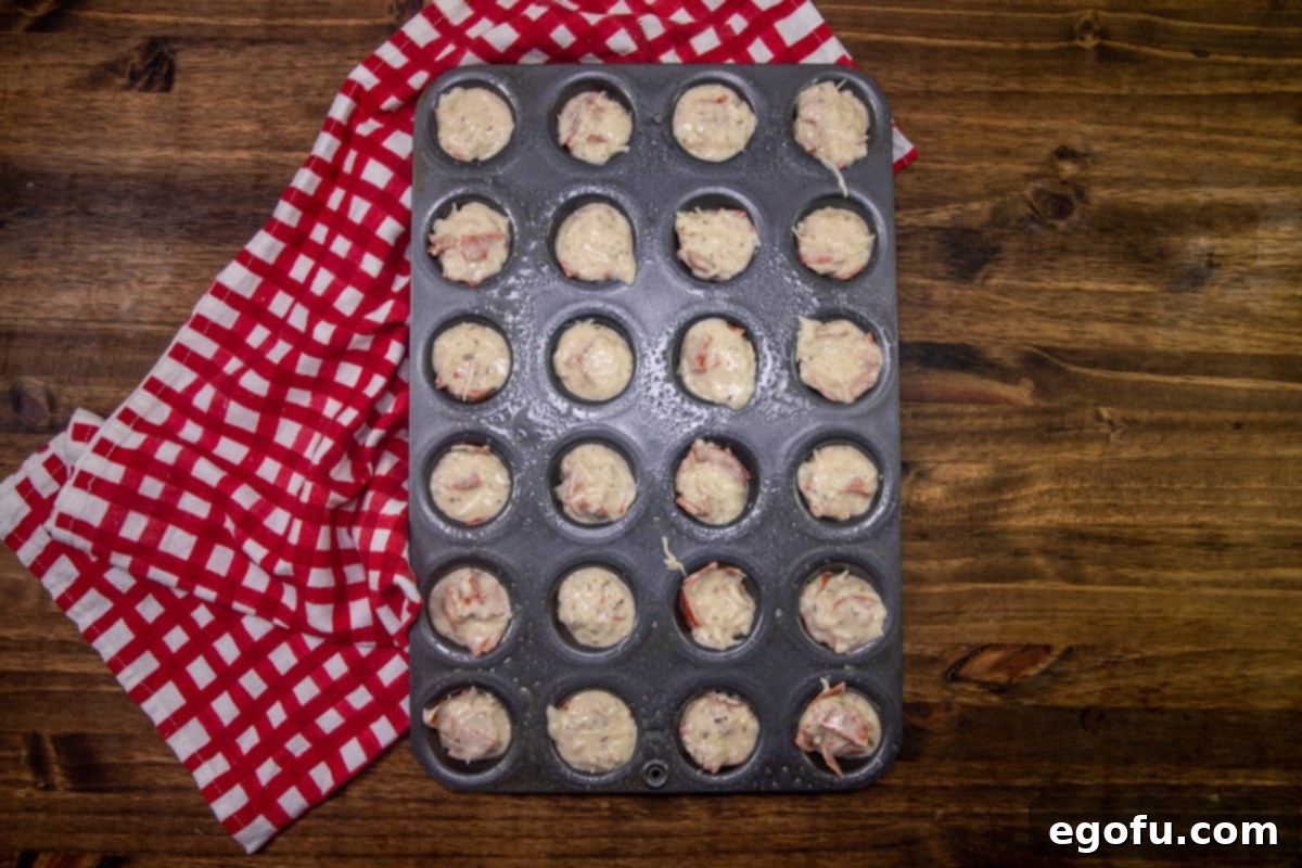 Cheesy Pepperoni Poppers 9 pepperoni pizza puffs batter poured into mini muffin tin.