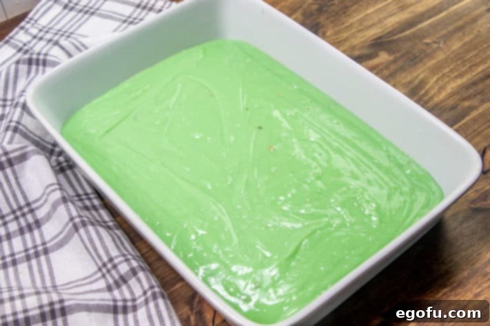 green pistachio cake batter poured into prepared baking dish